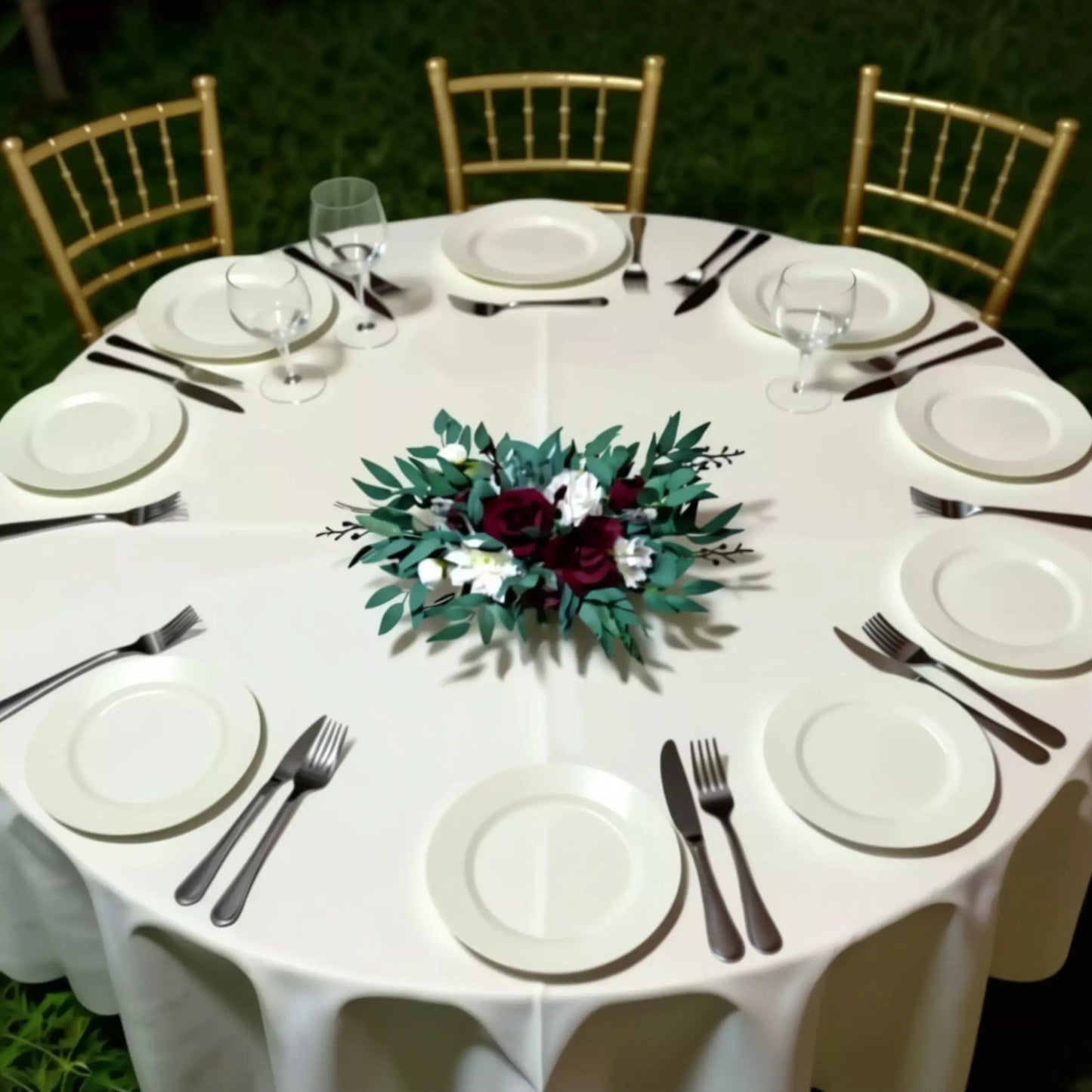 a beautifully set table for a formal event, with white tablecloths, plates, silverware, and a centerpiece of flowers.