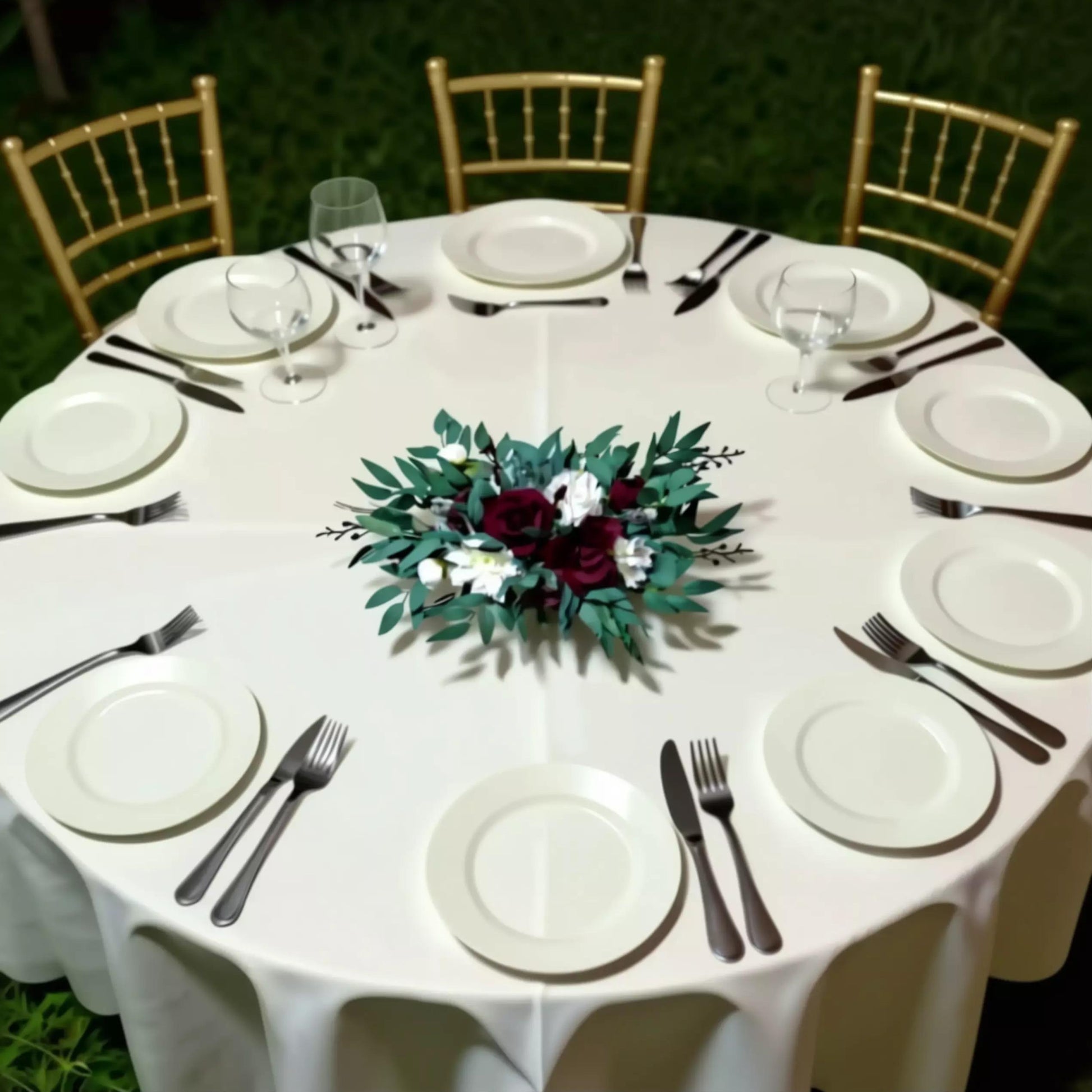 a beautifully set table for a formal event, with white tablecloths, plates, silverware, and a centerpiece of flowers.