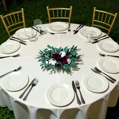 a beautifully set table for a formal event, with white tablecloths, plates, silverware, and a centerpiece of flowers.